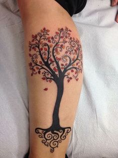 a woman's arm with a tree tattoo on the left side of her leg