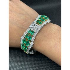 This is part of Chairish’s Fine Jewelry assortment.  This Art Deco Emerald Diamond Wedding Bracelet in 18K gold showcases 40 endlessly sparkling natural emerald, weighing 23.74 carat and diamonds weighing 7.09 carat. It measures 7.5 inches long in length.  Emerald enhances the intellectual capacity of the person. Designed with perfect oval cut emerald set horizontally in between the diamonds with diamond charm in center to make you stand out on any occasion or event. The elegant style complements the attire beautifully and this is a perfect Unique Gift, Bridal Shower Gift, Secret Santa Gift, Gift For Sister, Mother Daughter Gift, Bride To Be Gift, Bridesmaid Gift, Thanksgiving Gift, Anniversary Present, Christmas Gift or any Holiday Gift for Mother, Sister, Daughter, Grandma, Fiancé, Girlf Luxury Green Diamond Bracelet Hand Set, Formal Emerald Diamond Bracelet With Brilliant Cut, Green Diamond Bracelet For Formal Occasions, Luxury Green Brilliant Cut Diamond Bracelet, Luxury Green Hand Set Diamond Bracelet, Formal Emerald Diamond Bracelet, Luxury Green Tennis Bracelet For Formal Events, Emerald Tennis Bracelet With 17 Jewels For Wedding, Fine Jewelry Emerald Diamond Bracelet For Wedding