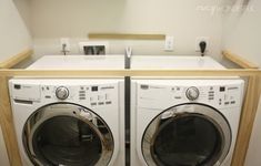 a washer and dryer in a small room with white cabinets on the wall