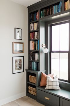 a window seat in front of a bookshelf filled with books