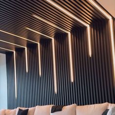 a living room filled with white couches and black striped wall behind it's walls