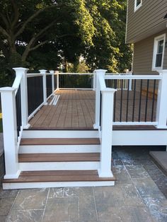 a deck with white railings and wood steps