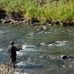 a man standing in the water while fishing