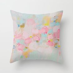 an abstract painting on a pillow with pink, blue and yellow colors in the background