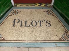 a door mat that says pilot's on it in front of a red door