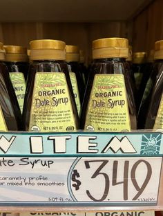 bottles of organic date syrup for sale in a grocery store's display case with price label