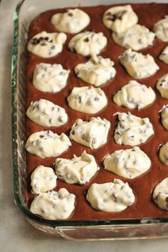 a baking pan filled with chocolate chip cookies and white icing on top of it