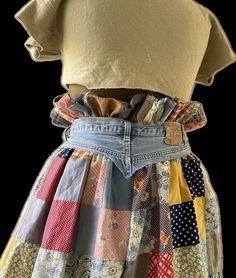 a woman's dress made out of patchwork and denims, with buttons on the back