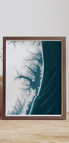 an aerial view of the ocean and land from above, framed in a wooden frame