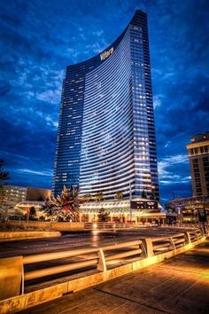 a very tall building sitting in the middle of a city at night with lights on