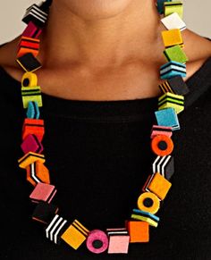 a woman wearing a colorful necklace made out of different colored squares and circles on it