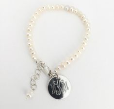 "Monogram Pearl Baby Bracelet Personalized, Monogram Freshwater Pearl Bracelet with Sterling Silver for Baby Gift Celebrate a new baby girl with this beautiful freshwater pearl bracelet with sterling silver tag and fittings. It includes a 1\" extender chain making it good for wearing as the baby grows into a toddler and little girl. . We will engrave a monogram or name onto the round pendant. Beautiful natural ivory color. Lobster Clasp. Comes in gift box. *Only for wear under supervision. Penda Personalized Adjustable Classic Pearl Bracelet, Classic Personalized Adjustable Pearl Bracelet, Classic Adjustable Personalized Pearl Bracelet, Classic Personalized White Pearl Bracelet, Silver Pearl Bracelet With Pearl Charm For Mother's Day, Personalized Classic Pearl Bracelet, Classic Personalized Pearl Bracelet, Hypoallergenic Pearl Bracelet For Birthdays, White Engraved Round Bracelets