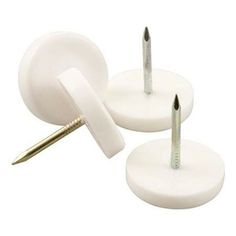 three screws are placed on top of two white plastic bases, one has a gold tip