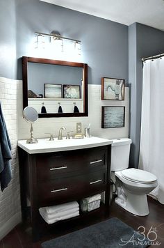 a white toilet sitting next to a sink in a bathroom under a mirror above it