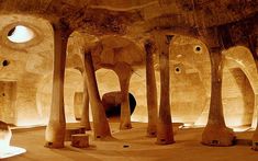 the interior of a building with multiple columns and round holes in each column, surrounded by trees