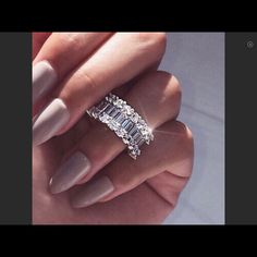 a woman's hand holding a diamond ring