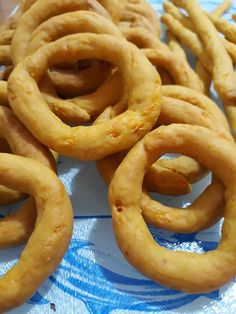 some very tasty looking food items on a blue and white table cloth with water in the background