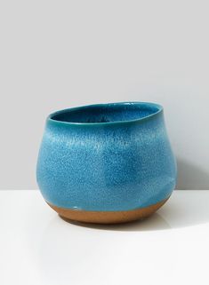 a blue bowl sitting on top of a white table