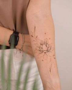 a woman's arm with a flower tattoo on the left side of her arm