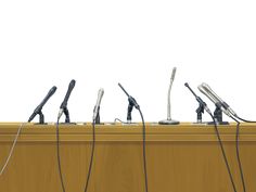 a row of microphones sitting in front of a podium