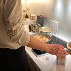 a person cooking food in a kitchen on the stove top with a can of butter