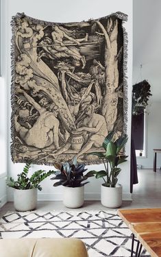 a tapestry hanging on the wall in a living room with plants and potted plants