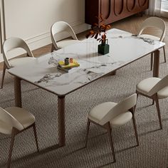 a marble dining table with chairs around it