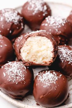 chocolate covered coconut balls with white sprinkles on the top and one in the middle