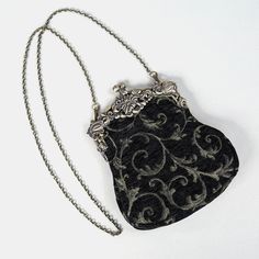 Introducing our captivating collection of Chatelaine purses, inspired by the elegance of the Victorian era.Available in three sizes—Large, Medium, and Small—these purses offer versatility and style. The Large and Medium sizes can be used as both a clutch and a crossbody purse, as we provide two chains for each size: 50" and 13" in length. This allows you to effortlessly switch between crossbody and clutch styles.Let's focus on the Chatelaine Large Crossbody Purse:With a frame width of 6.25" and a height of 8", this purse comfortably holds larger items like the iPhone 14 Pro Max and a passport. It features a small slip pocket for cards or small essentials, and the 1.5" bottom depth provides ample space for your necessities.The Large Crossbody Purse includes two chains, each with brass hooks Elegant Handmade Black Bag, Elegant Black Evening Bag With Removable Pouch, Black Vintage Bag For Gifts, Elegant Handmade Evening Shoulder Bag, Elegant Evening Handmade Shoulder Bag, Elegant Handmade Black Clutch, Elegant Black Handmade Clutch, Vintage Black Pouch Evening Bag, Elegant Pouch Evening Bag For Everyday Use