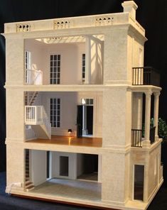 a doll house with stairs and balconies on the second floor is made out of wood