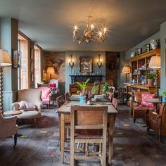 a living room filled with lots of furniture and a chandelier hanging from the ceiling