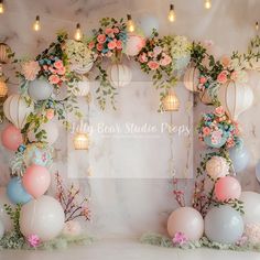 an arrangement of balloons, flowers and lanterns on a marble wall for a wedding reception