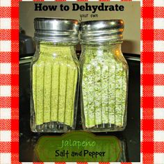 two jars filled with green food sitting on top of a counter next to a red and white checkered table cloth