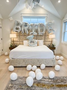 a bedroom decorated with balloons and the word bride spelled out in large silver foil letters