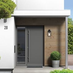 an entrance to a house with two potted plants on the side and one door open