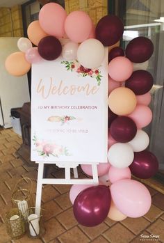 a welcome sign surrounded by balloons and flowers