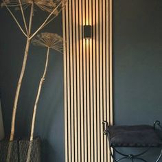 a black and white striped wall in a room with a plant next to the wall