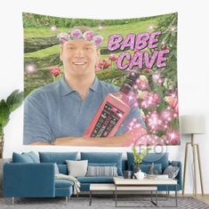 a man holding a pink calculator in front of a wall tapestry that says babe cave