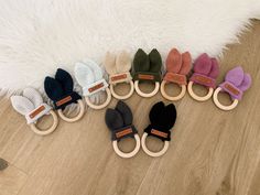 six pairs of knitted mittens are arranged in a row on a wooden floor