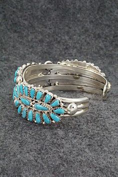 This turquoise and sterling silver bracelet was made by Navajo silversmith Jaz Wilson. The inside is signed J Wilson and S/S.Size: 5 3/4" (will fit up to a 6 1/2" wrist)Gap: 3/4"Width: 7/8"Free shipping on all orders! We ship with USPS and always include tracking. All orders ship within a day of payment.Returns are accepted up to 30 days after you receive your order. Just send us a message. Our shop offers cash back or store credit. The item must be returned in new condition. Southwestern Blue Sterling Silver Bangle Bracelet, Southwestern Blue Sterling Silver Bangle, Southwestern Style Blue Inlay Bracelets, Southwestern Style Blue Sterling Silver Bracelet, Southwestern Style Turquoise Inlay Bracelets, Southwestern Turquoise Inlay Bracelet, Southwestern Turquoise Bangle, Turquoise Inlay Bracelet For Collectors, Southwestern Sterling Silver Bracelet With Turquoise Inlay