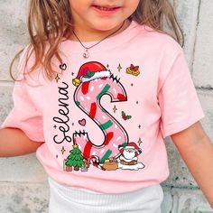 Personalized Christmas Kids Shirt, Custom Alphabet Christmas Kids Shirt, Baby Christmas Toddler, Baby Christmas Tee, Christmas Gift For Kids A T-shirt is a daily must-have item you should have in your wardrobe. Our designed T-shirts are quite easy for you to wear or mix with other items. Above all, it's extremely convenient and suitable for any gender. You can wear our designs anywhere you want: at home, at a gym, or hang out with friends. Our shop wants to bring you trendy, quality and cost-effective shirts. PRODUCT DETAILS: Printed in the USA Worldwide shipping Print type: DTG Material: Cotton and polyester Sizing: Depending on colors and styles Style: Classic t-shirts, hoodies, sweatshirts, tank tops, youth T-shirts, baby bodysuits, etc Can be printed on both sides The second side: + $4 Kids Christmas T Shirts, Christmas Shirts For Kids, Toddler Christmas, Christmas Tees, Christmas Gifts For Kids, Christmas Baby, Christmas Tshirts, Kids Tops, Kids Christmas