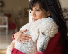 a woman holding a white stuffed animal in her arms