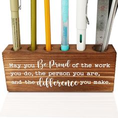 a wooden pen holder with pens, pencils and rulers on it that says may you be proud of the work you do, the person you are, and the distance you make