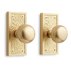 two gold door knobs on a white background