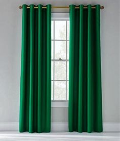 the green curtains are hanging in front of a window with gold hardware on each side