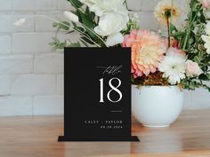 a table number with flowers in a vase