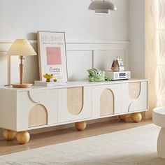 a living room with a white couch and table next to a lamp on top of a rug