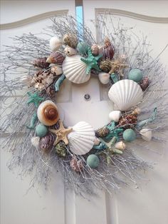 a wreath with seashells and seaweed on the front door