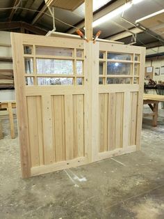 two wooden doors are being built in a workshop with other woodworking tools on the floor