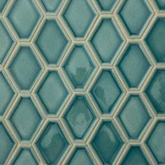 a close up view of a blue tile wall with hexagonal tiles on it